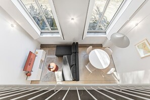 A modern interior with a sofa, dining table, and a 'GUEST READY' sign. - GuestReady-Rou27-G (Porto)