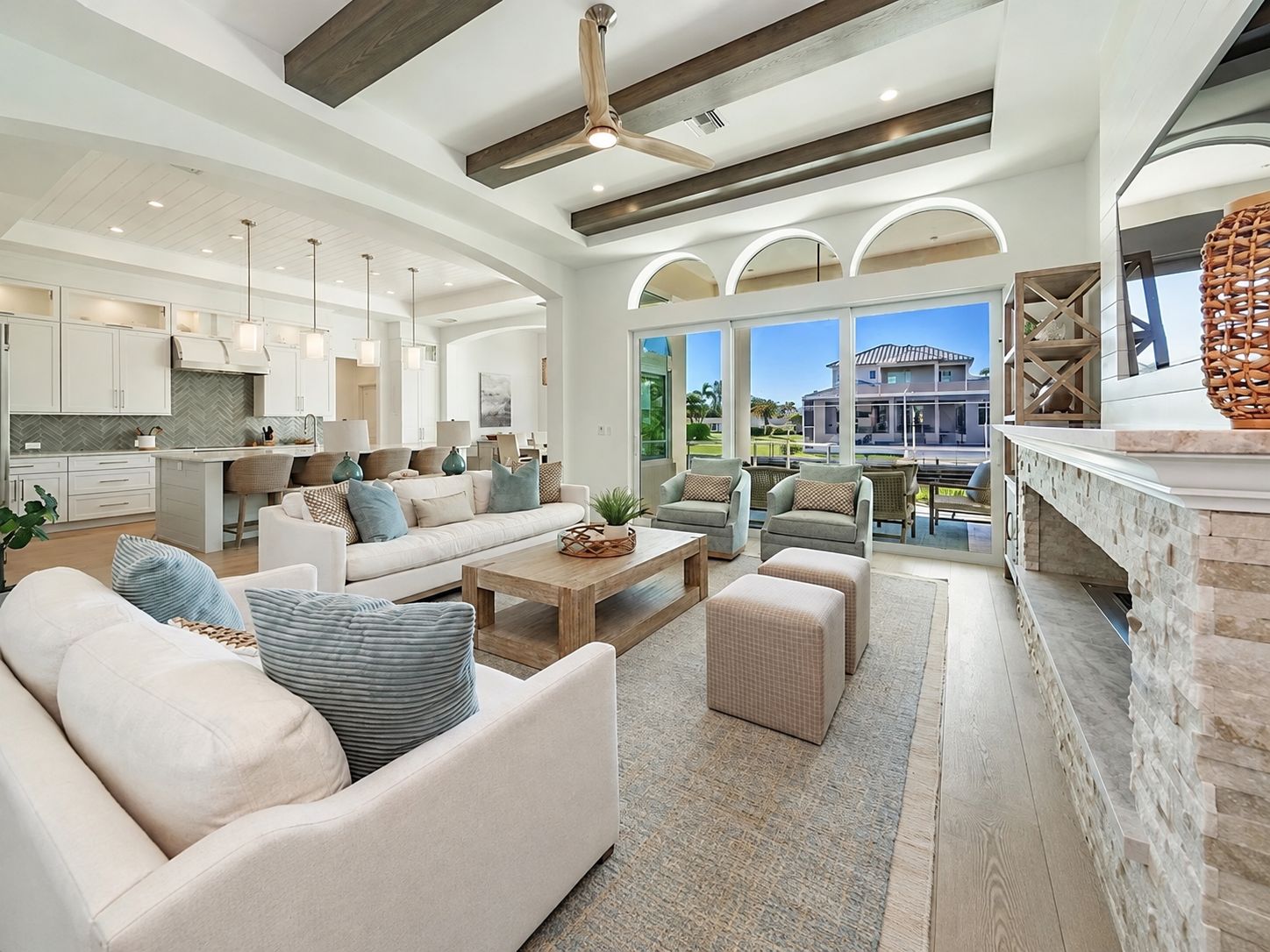 A spacious living area with a sofa, chairs, and a coffee table. There is a kitchen area with cabinets and a dining area with a table and chairs.