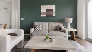 A living room with a sofa, two armchairs, a coffee table, and a lamp. - Landing | Amazing 2BD in East Naples (Naples)