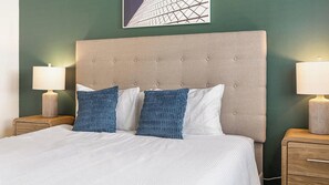Ein Hotelzimmer mit einem großen Bett, zwei Nachttischen und einer Kopfteil.