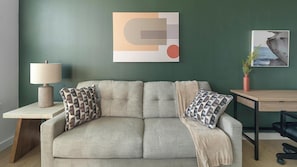 A modern living room with a sofa, a lamp, a table, and a framed picture on the wall. - Landing | Modern 1BD in Sunnyside (Houston)