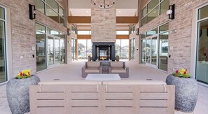 A modern outdoor lounge area with a central fire feature, seating, and large planters. - Landing | Incredible 1BD in Loughman (Davenport)
