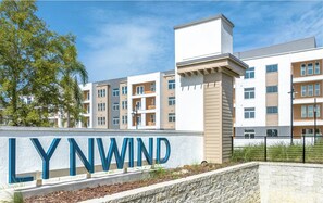 Un moderno complejo de apartamentos llamado LYNWIND con un letrero de entrada destacado.