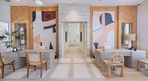 A hotel lobby with a reception desk, two seating areas, and a hallway leading to the rooms. - Landing | Spectacular 2BD in Loughman (Davenport)