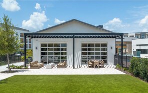 A modern building with a covered patio area, large windows, and outdoor furniture. - Landing | Stunning 1BD in Loughman (Davenport)