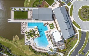 An aerial view of a resort with a large swimming pool, lounge areas, and a parking area. - Landing | Amazing 2BD in Loughman (Davenport)