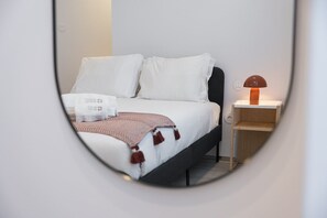 A hotel room with a bed, a bedside table, and a lamp. - GuestReady- Rou 27- B (Porto)