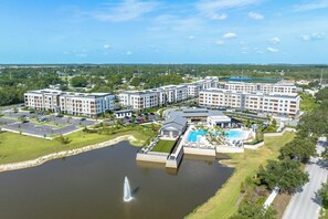 A hotel complex with multiple buildings, a swimming pool, and a fountain. - Landing | Incredible 2BD in Loughman (Davenport)