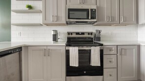 A kitchen with a built-in microwave, oven, and coffee maker. - Landing | Beautiful 1BD, Clubhouse, Pool (Sarasota)