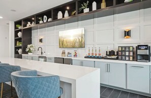 A modern kitchen with a central island, built-in cabinets, and a coffee machine. - Landing | Incredible 1BD, Pool, Clubhouse (Sarasota)