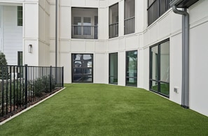 Un edificio moderno con techo plano, ventanas amplias y un césped cuidado.