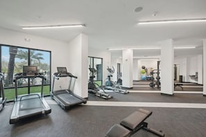 A gym with treadmills, stationary bikes, and weight equipment. - Landing | Stylish 1BD, Pool, Gym (Sarasota)