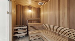 Un sauna avec des bancs en bois et un banc muni d’un porte-serviettes.