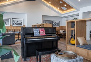 A modern living room with a grand piano, a sofa, and a dining area. - Blueground | Scofield Farms, pool, nr Walnut Creek Park (Austin)