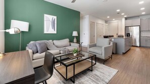 A modern living room with a sofa, armchairs, a coffee table, and a dining table. - Landing | Incredible 2BD, Courtyard (Garland)