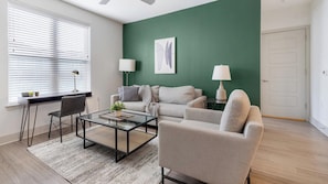 A modern living room with a sofa, armchair, and coffee table. - Landing | Incredible 2BD, Courtyard (Garland)