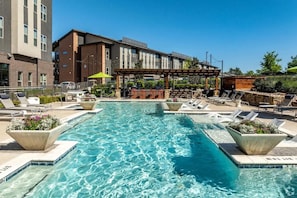 A rectangular pool with clear blue water, surrounded by lounge chairs and planters. - Landing | Incredible 2BD, Courtyard (Garland)
