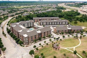 A residential area with multiple apartment buildings, roads, and green spaces. - Landing | Incredible 2BD, Courtyard (Garland)