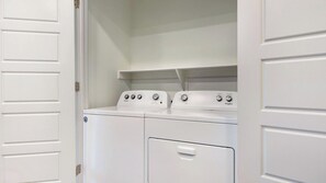 Une buanderie équipée de deux machines à laver Whirlpool à chargement frontal.