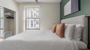 A hotel room with a large bed, a wardrobe, a window with blinds, and a painting on the wall. - Landing | Beautiful 1BD, Gym (Birmingham)