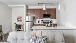 Eine moderne Küche mit Holzschränken, einem Edelstahl-Kühlschrank und einem Einbauofen.