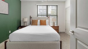 A hotel room with a bed, bedside tables, a window with blinds, and a door. - Landing | Stunning 1BD, Gym (Birmingham)