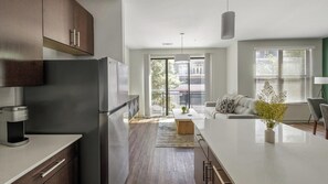 A modern kitchen with a built-in refrigerator, a coffee machine, and a large island. - Landing | Stunning 1BD, Gym (Birmingham)