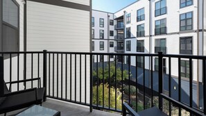 A balcony with a black railing, a glass table, and a chair. - Landing | Stunning 1BD, Gym (Birmingham)