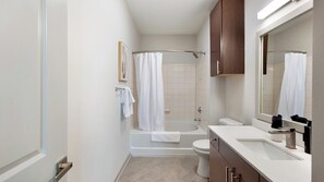 Un baño moderno con bañera, inodoro y tocador.