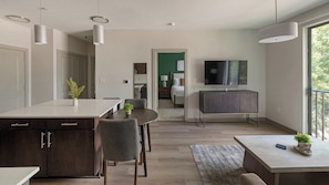 Eine moderne Küche mit Essbereich, einem an der Wand befestigten Fernseher und einem Balkon mit Aussicht.