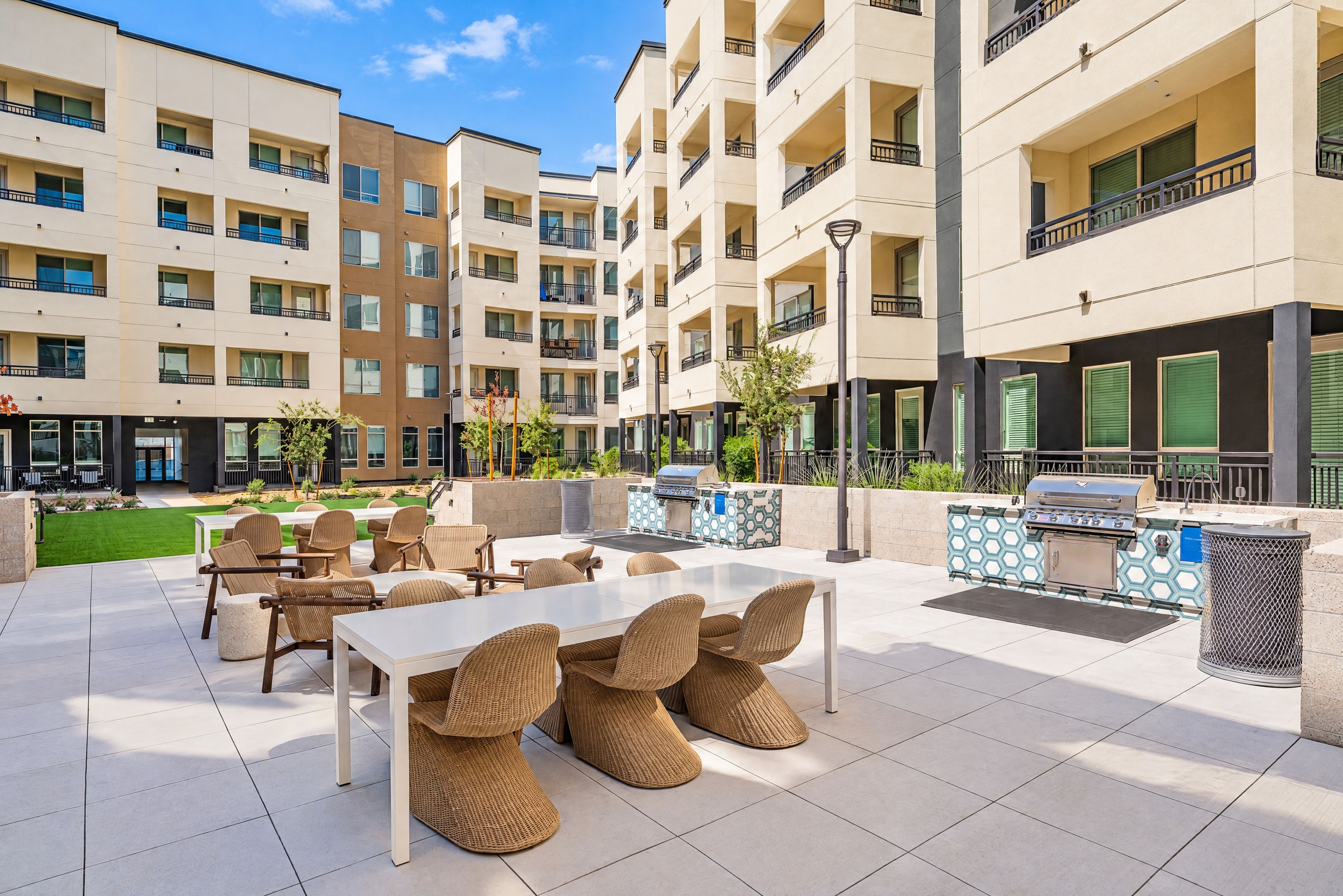 Un'area patio esterna moderna con posti a sedere e una stazione barbecue.