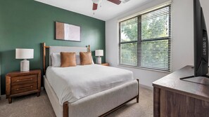 A bedroom with a bed, nightstands, a desk, and a window with blinds. - Landing | Stunning 2BD, Gym (Birmingham)