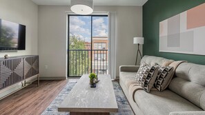 A modern living room with a sofa, coffee table, and TV. - Landing | Stunning 2BD, Gym (Birmingham)