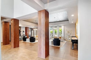 A spacious hotel lobby with high ceilings, large windows, and a modern design. - Landing | Chic 3BD, Pool, Gym (Oxford)