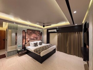 A modern bedroom with a large bed, a built-in wardrobe, and a ceiling fan. - Hotel Suncity And Zaffran (Jangipur)