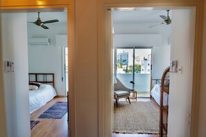 A hotel room with a bed, a chair, a balcony, and a ceiling fan. - Stylish 3BR w/ Huge Veranda and City View, Nicosia (Nicosia)