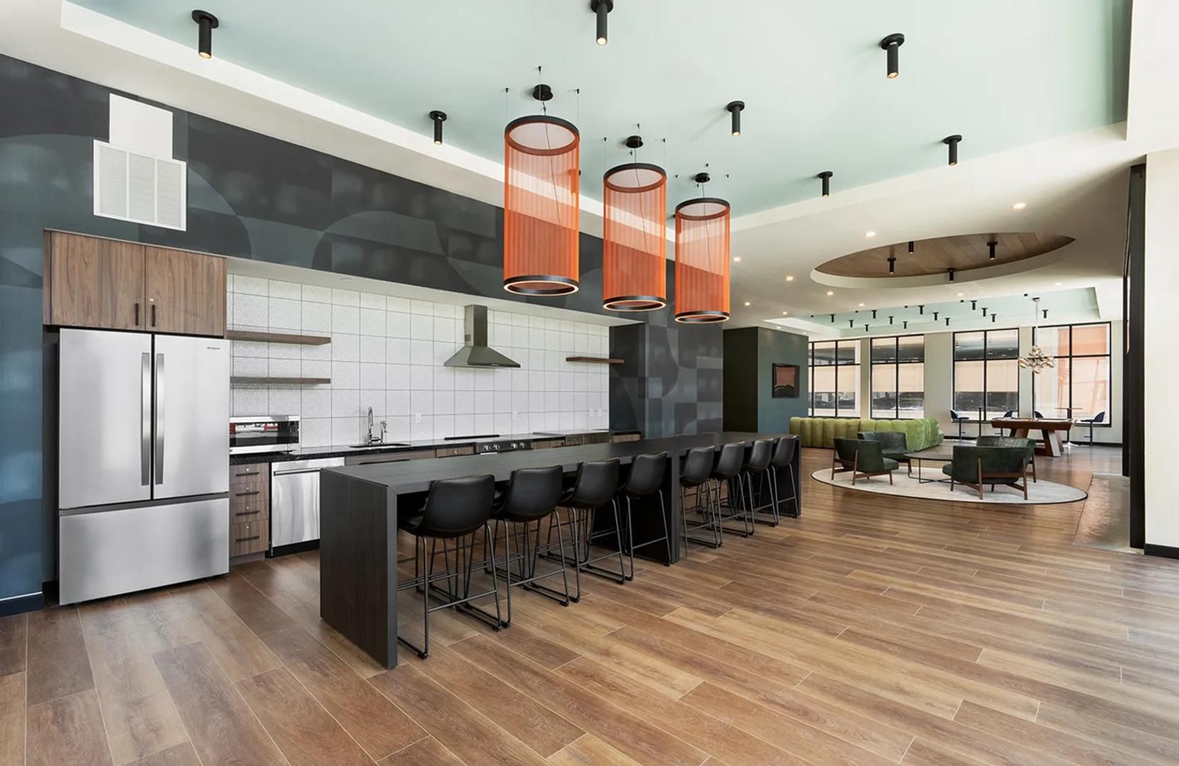 Una cocina moderna con una isla central, taburetes de bar e iluminación colgante.