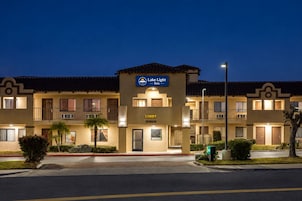 Un hotel de varios pisos con un letrero llamativo que dice 'Lake Light Inn' y 'Recepción' en la planta baja.