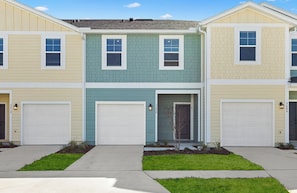 A row of townhouses with two-story garages and a central entrance. - Landing | Stylish 3BD, Pool, Clubhouse (Jacksonville)