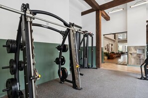 Ein Fitnessraum mit Gewichte und eine Lounge mit Sitzgelegenheiten.