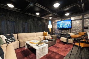A modern living room with a sofa, coffee table, and a TV mounted on a textured wall. - Landing | Beautiful 1BD, Rooftop Lounge (Richmond)