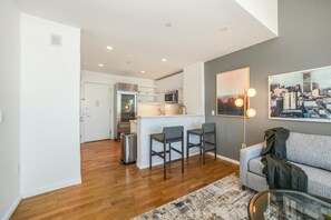 A modern apartment with a kitchen, dining area, and living room. - Landing | Incredible 2BD, Pool, Gym (Roy)