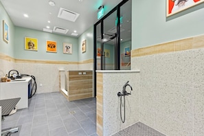 A modern bathroom with a shower, a sink, and a reception desk. - Landing | Spectacular 2BD, Pool (Tampa)