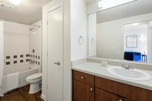 Une salle de bain avec une baignoire, des toilettes, un lavabo et un miroir.