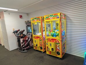 A room with two yellow claw machines and a toy gun display. - Oceanview-Corner Condo-2 Private Balconies-Hot Tubs, Heated Pools, Lazy Rivers. (Myrtle Beach)
