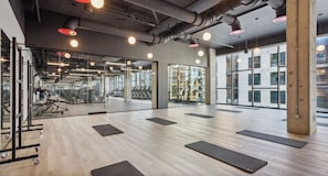 A gym with exercise equipment, mats, and a large window. - Landing | Stunning 1BD, Pool, Gym (Nashville)