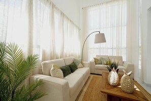 A modern living room with two sofas, a floor lamp, and a coffee table with decorative vases. - Paradise Private Pool Villa (Punta Cana)