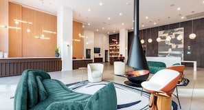A modern lobby with a reception desk, seating area, and a fireplace. - Landing | Modern 1BD, Pool, Gym (Nashville)