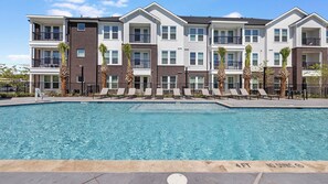 A multi-story residential building with a swimming pool in front. - Landing | Chic 1BD in Whitestone (Fort Worth)
