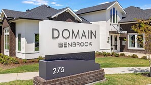 A sign for Domain Benbrook with a modern architectural style, featuring a prominent entrance and a well-maintained lawn. - Landing | Modern 1BD in Whitestone (Fort Worth)